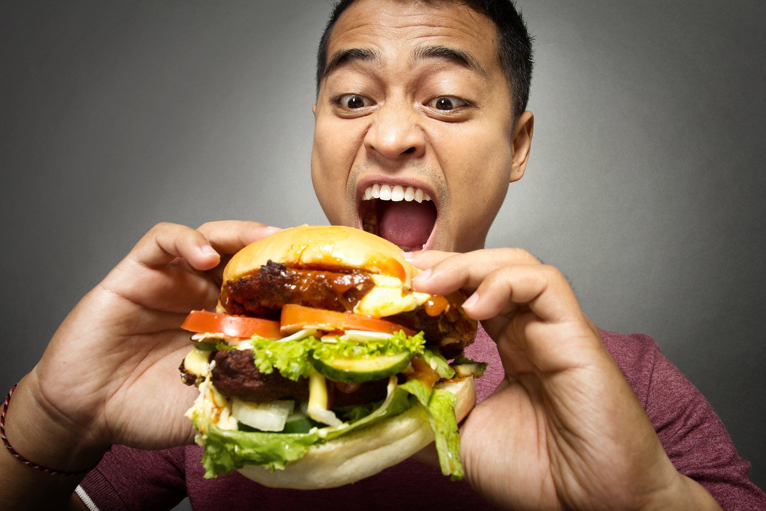 Люди едят людей название. Кушает гамбургер. Человек ест гамбургер. Поедание гамбургеров. Люди едят бургеры.
